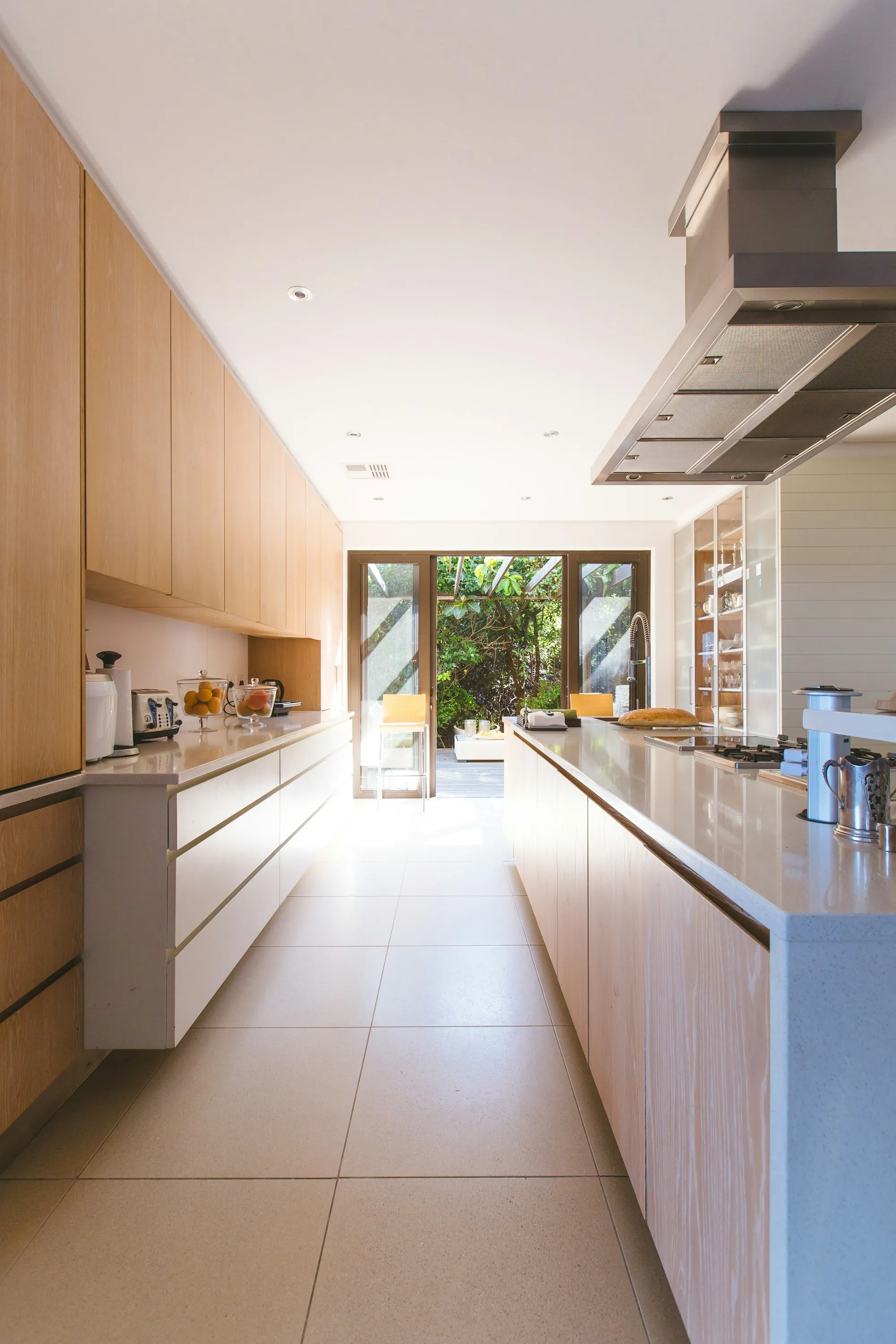 Renovated open-plan kitchen and living room with white cabinets and a wood-topped island