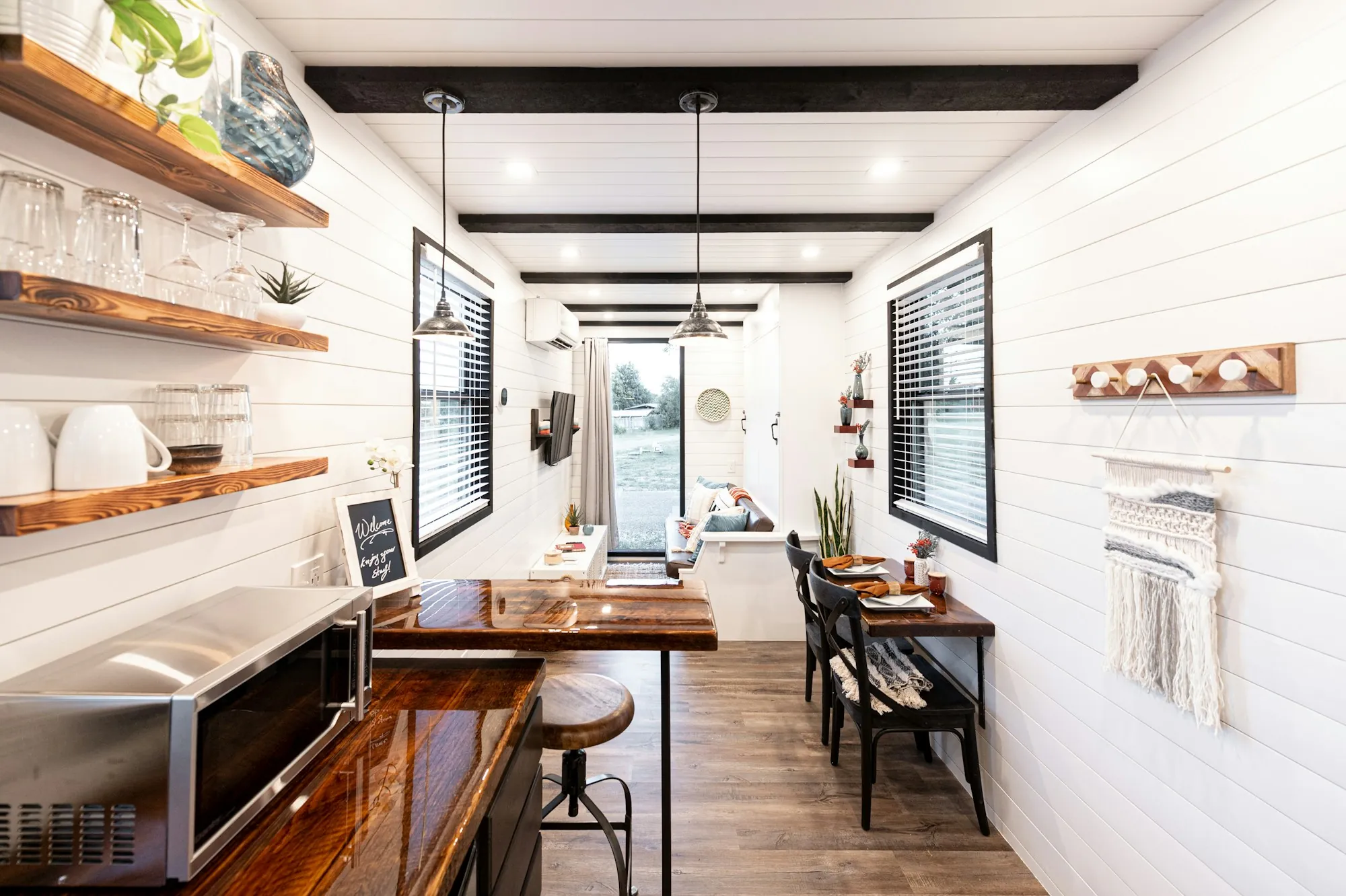 Small detached backyard cottage with a front porch and large windows