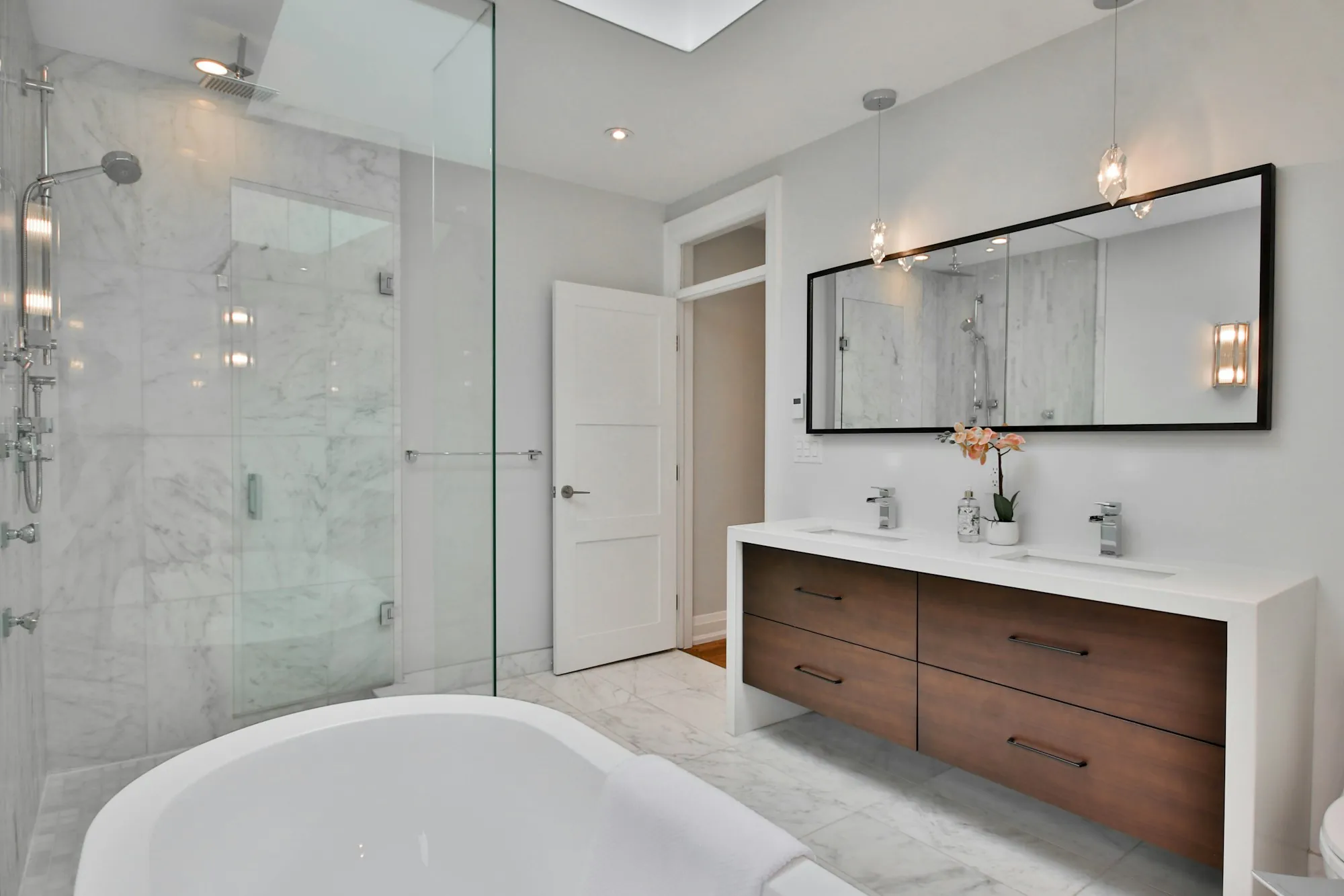 Remodeled bathroom with a glass walk-in shower and gray tile