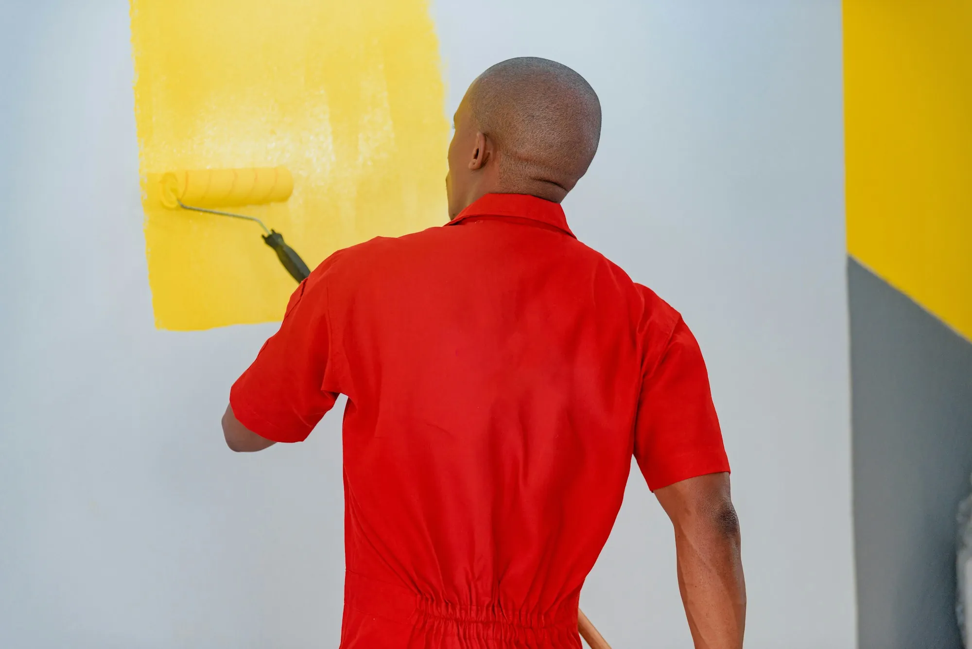 Painter cutting in a crisp line along white ceiling trim